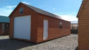 Log sided 16x36 A-frame garage with weathered copper roof.