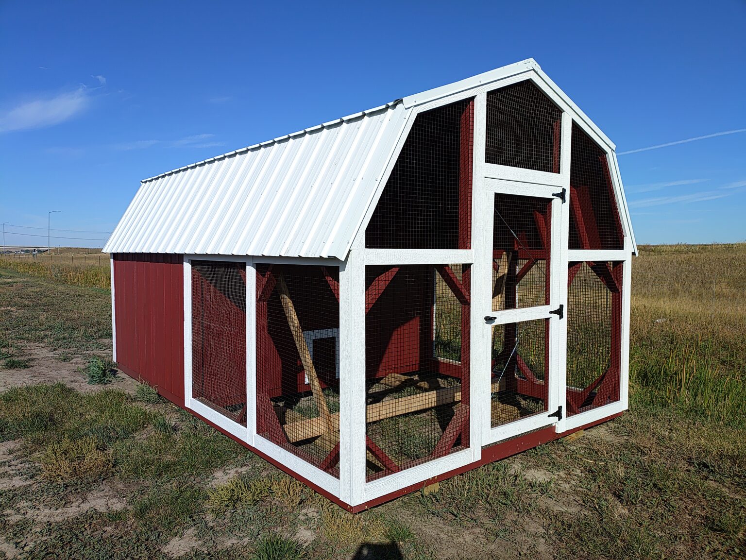 Red and white 10x16 chicken coop with attached run.